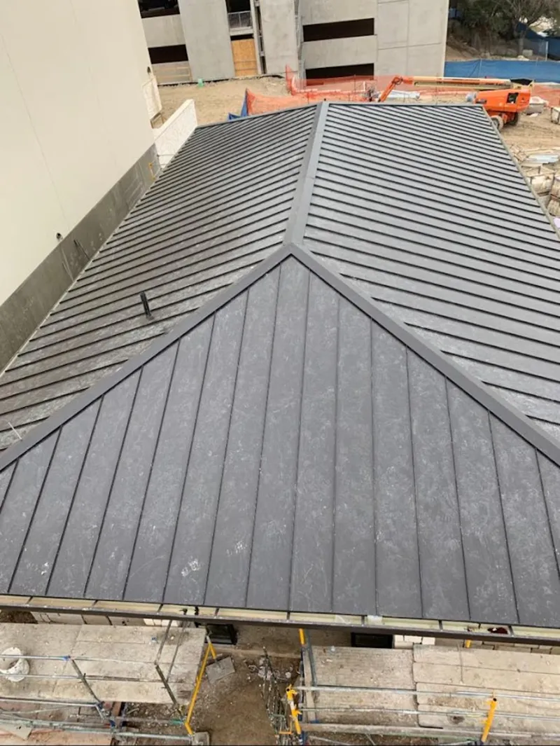 Commercial metal roof construction with crane equipment in West Windsor